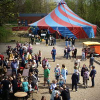 "Eine Aufnahme eines Zirkuszeltes mit Menschen davor"